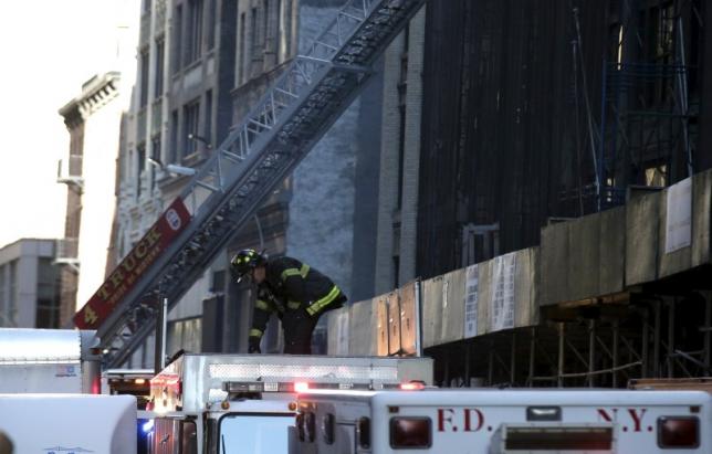 A New York City firefighter works on the scene where a building undergoing demolition work partially collapsed, in New York