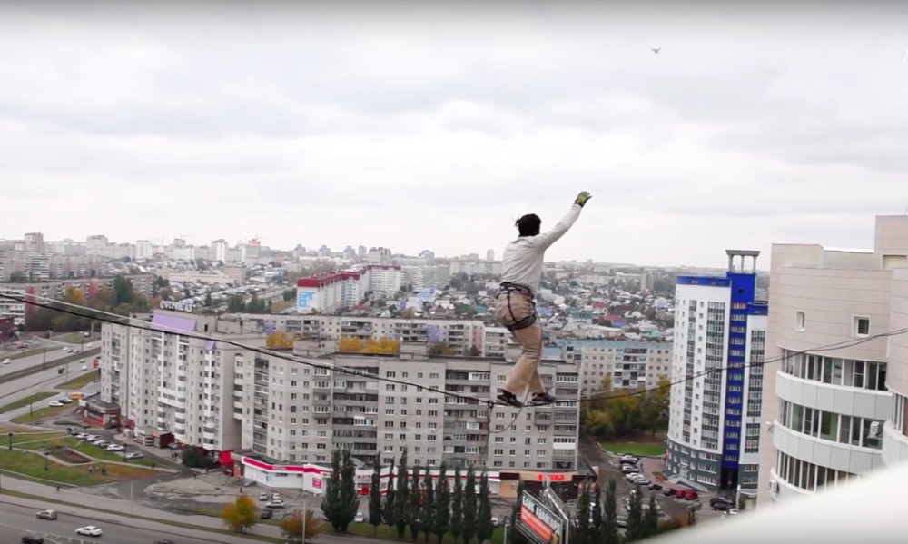 Рискованный проход экстремала по стропе между 16-этажными зданиями в Барнауле попал на видео 