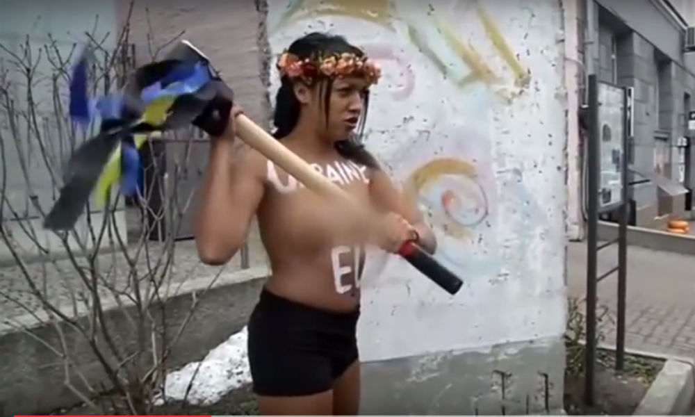 Нападение девушки с голой грудью на фрагмент Берлинской стены в Киеве сняли на видео 