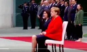 Меркель вынуждена сидя слушать гимны
